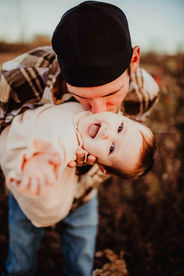 father and baby daughter play together during fall family photo session