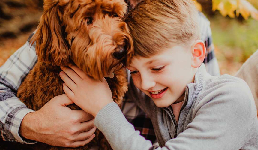 Noblesville Dad and son hugging their family dog during a cozy fall family session in Indiana