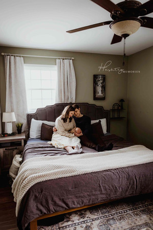 couple welcomes new baby in their master bedroom suite during a lifestyle family photography session in fortville, Indiana