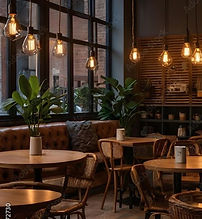 Cozy modern cafe interior with warm lighting, comfortable seating, and lush plants creates