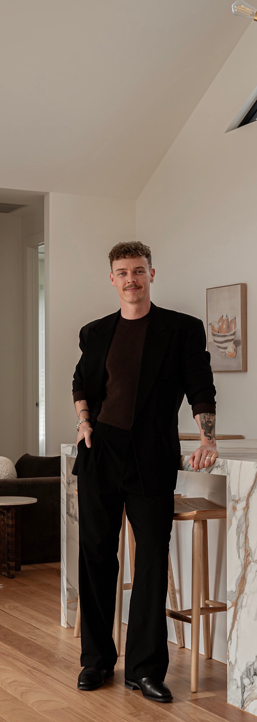 Keegan Bell director of curated interiors featured in a black suit in one of his interior styling projects