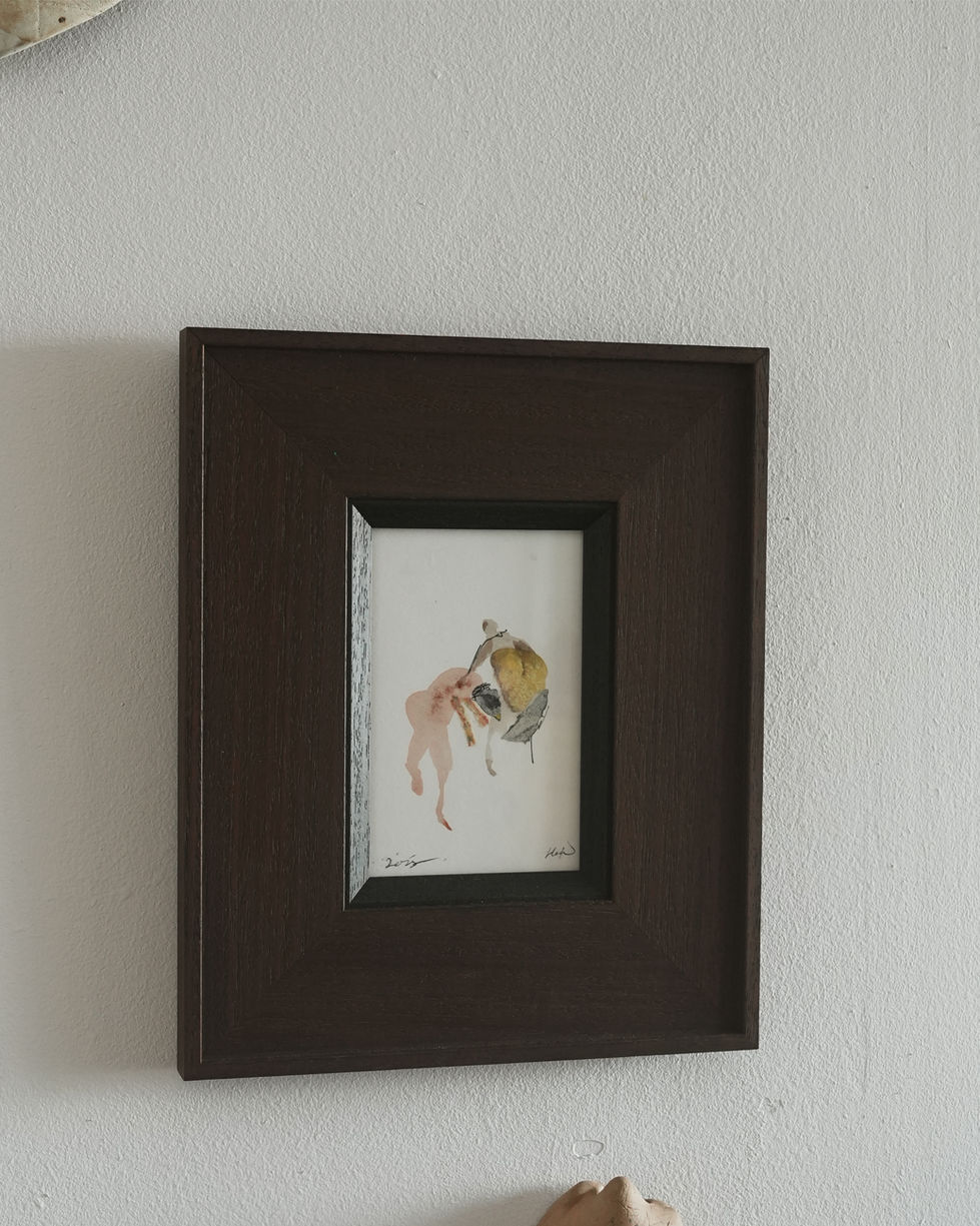 a framed picture of a wrestling between human and bird