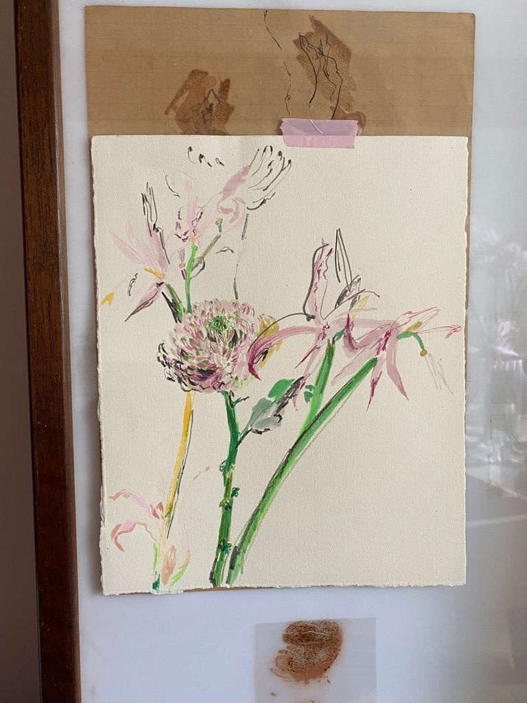 a painting of flowers is taped to a wall