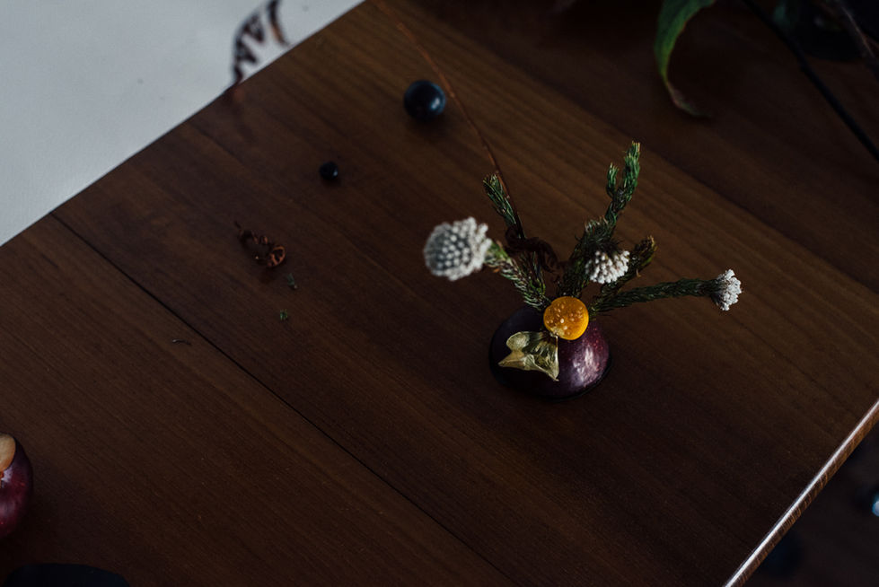 a vase filled with flowers sits on a wooden table