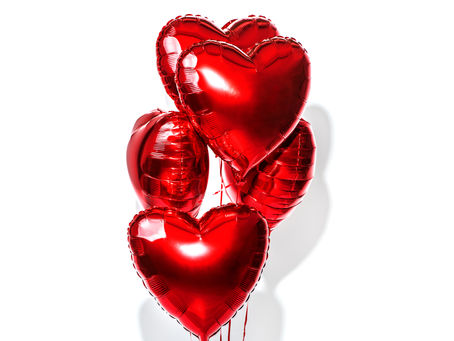 rote luftballon Herzen schweben vor einer weissen Wand