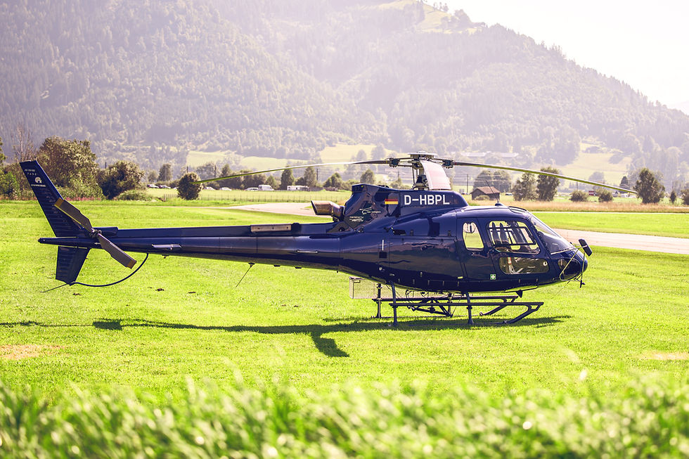 blue helicopter stands on a green lawn at an airfield