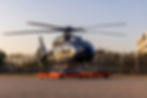 matter dunkler Helikopter auf einer Platform in der Sonne bei blauem Himmel
