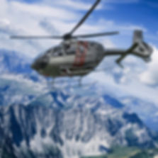 grüner Hubschrauber mit roten Streifen fliegt durch sommerliches Alpenpanorama