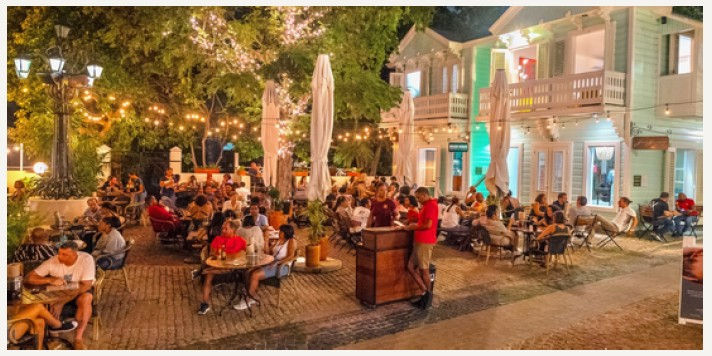 Outdoor dining at BRGR Haus in Kura Hulanda, Curaçao, under string lights and tropical trees.