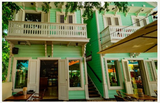 Restored green heritage building housing BRGR Haus in Kura Hulanda, Curaçao.