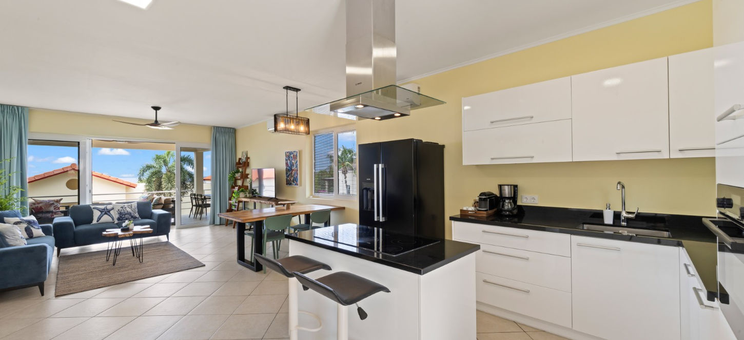 Open kitchen with island seating modern Curaçao apartment ocean view condo