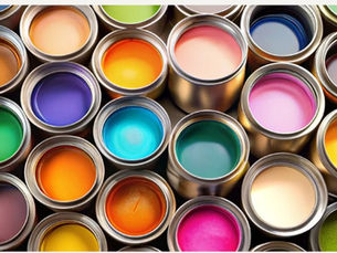 Open paint cans displaying a range of vibrant colors used for interior and exterior finishes in tropical homes.