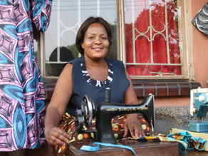 A photo of Charity at Zambia's Fly Deaf community initiative, with a trusty Singer sewing machine.