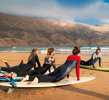 Moniteur de The Little Kasbah donnant des consignes à ses élèves sur la plage d'Imsouane avant une session de surf