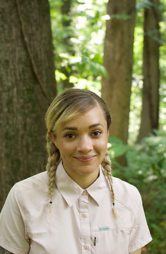 This is a portrait of Ari with a background of trees.