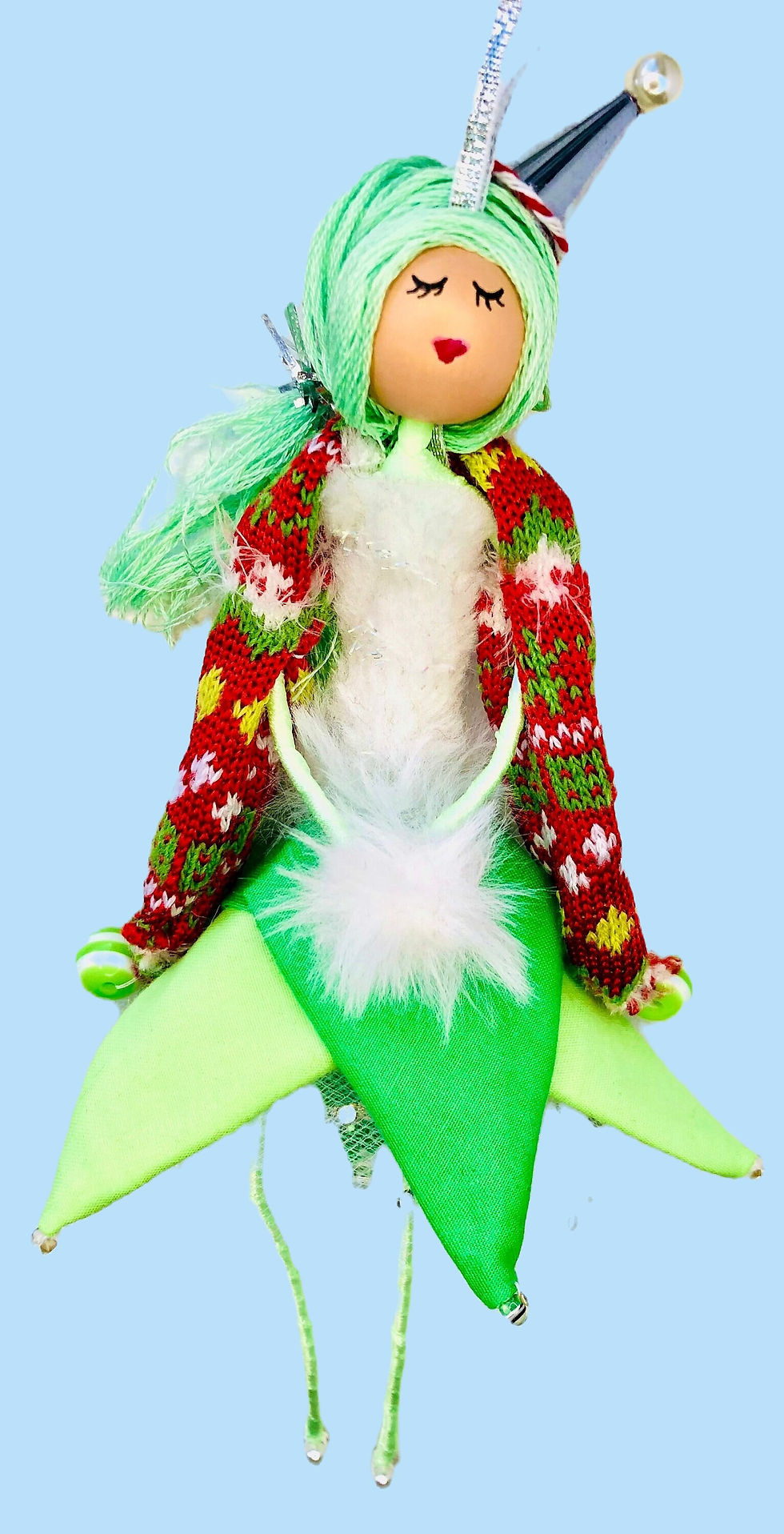 elf doll wearing green dress and red cape with green hair