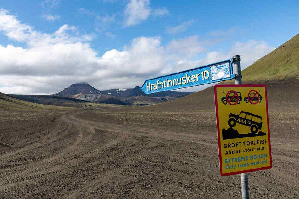 Vista general de un camino de tierra de Islandia donde se observan varias señales de tráfico a la derecha con inscripciones en el idioma local que indican la necesidad de atraversarlo en vehículo 4x4.