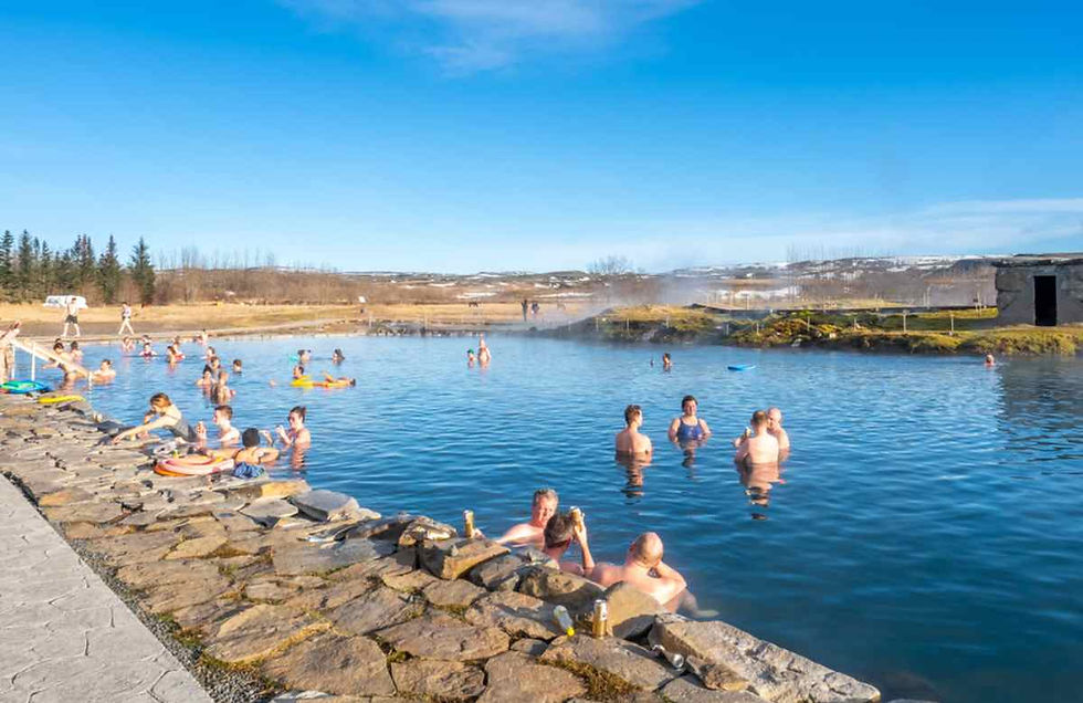 Bañistas disfrutando de Secret Lagoon en Flúðir, piscina termal al aire libre del Círculo Dorado.