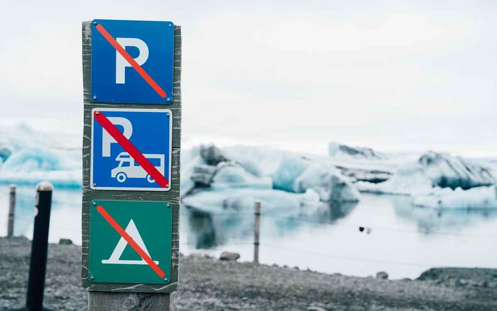 A set of road signs inform about the prohibition of camping and/or parking in the area.