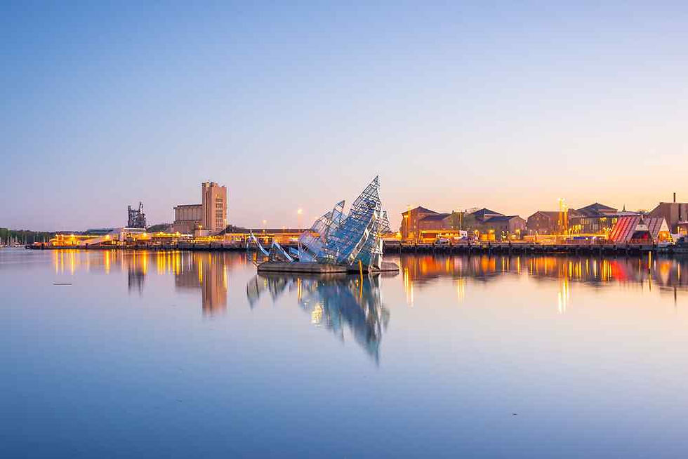 Dusk harbor skyline with a glass sculpture on calm water, city lights reflecting in a tranquil pastel sky