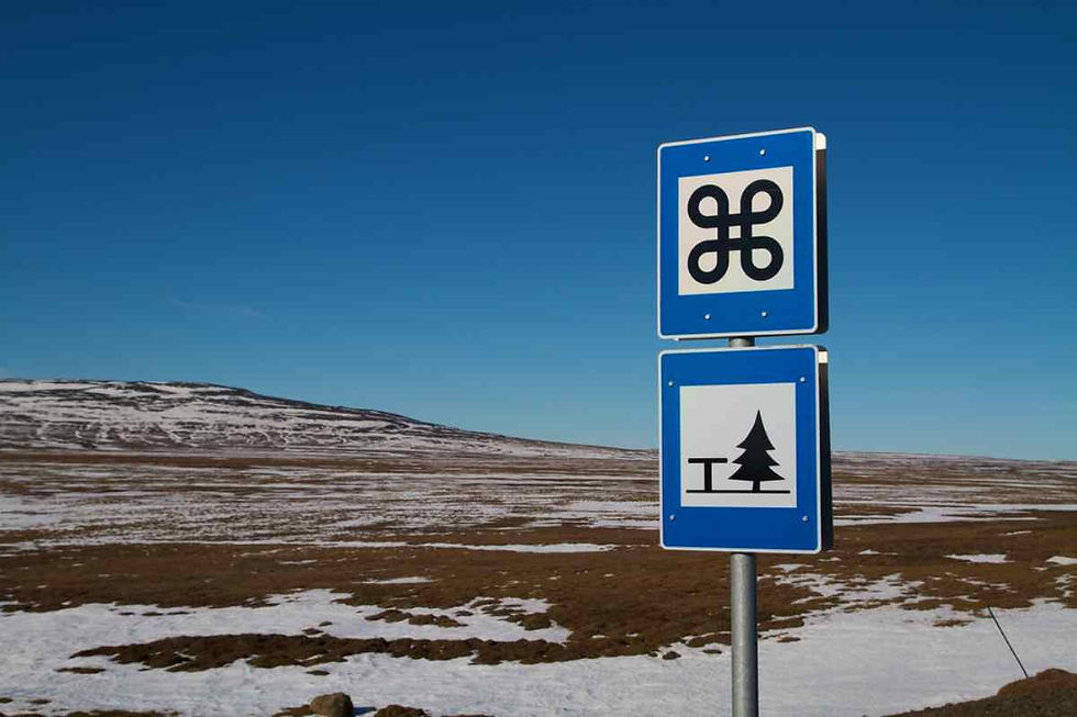 Plano detalle de unas señales de tráfico cuadradas y azuladas de carácter informativo en un paraje islandés nevado.