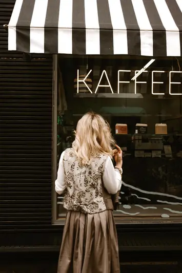 Schatzi Dirndl Model in Weste vor Schaufenster
