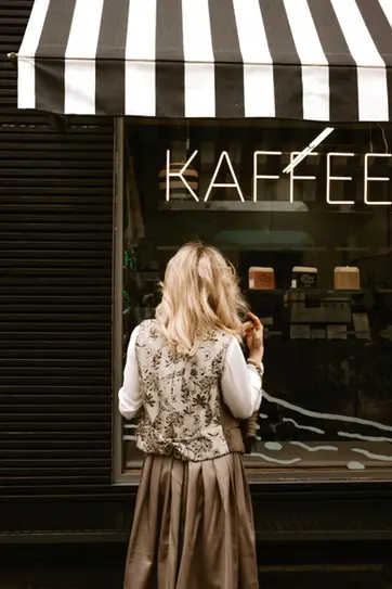 Schatzi Dirndl Model in Weste vor Schaufenster