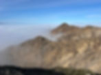 Mountain peaks rising above a thick sea of clouds.