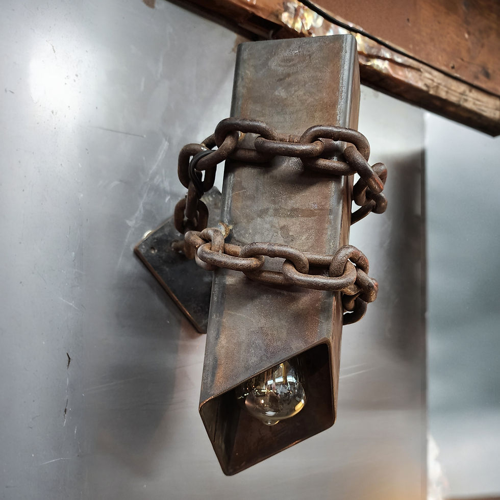 Thumbnail: industrial wall sconce made from raw steel with heavy chain wrapped around housing