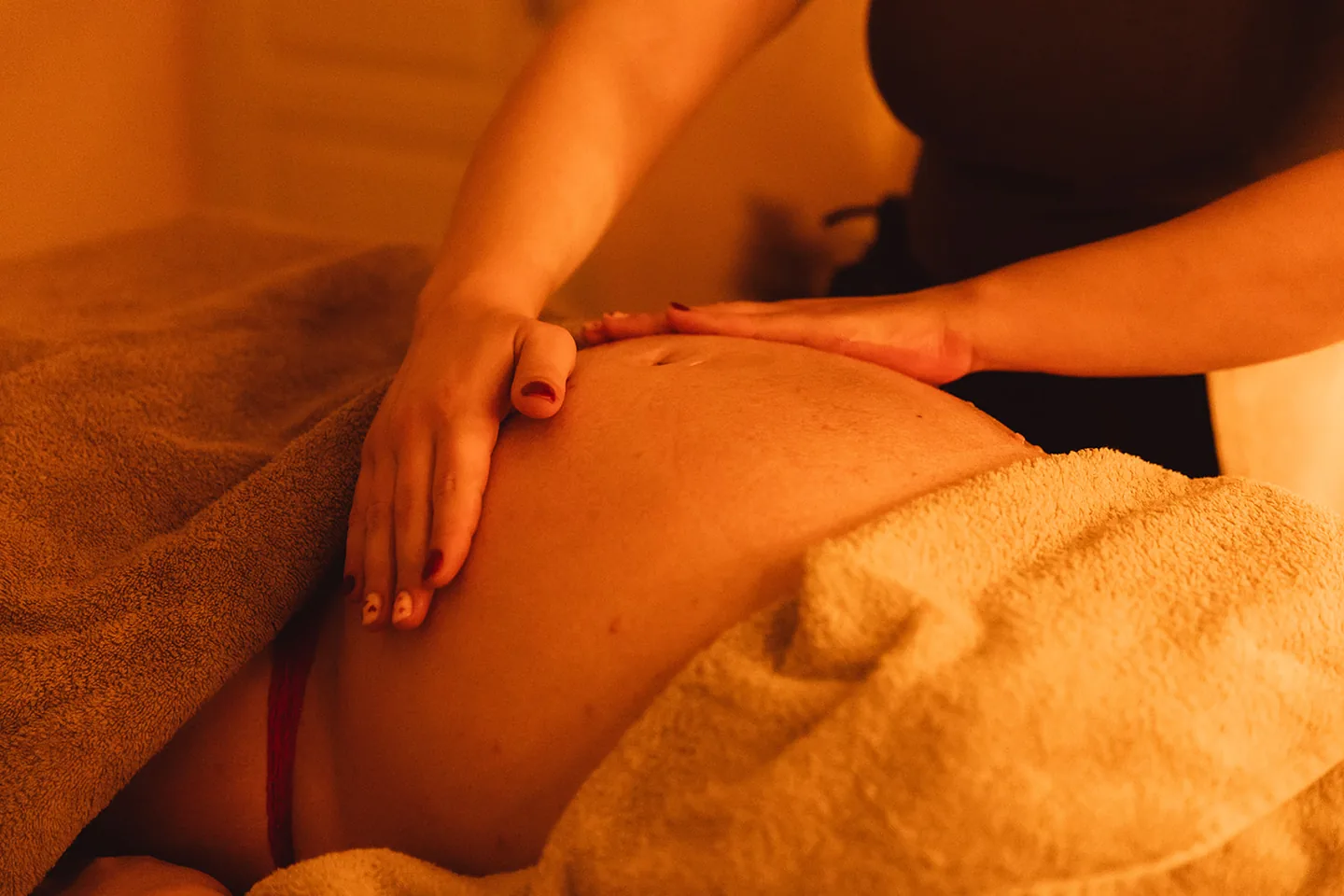 Massage doux du ventre d’une femme enceinte lors d’un massage prénatal