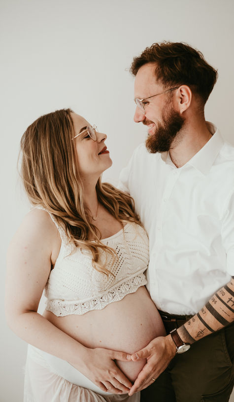 Paar beim Babybauchshooting Hildesheim hält den Babybauch.