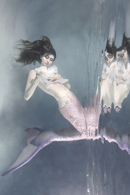 pink little mermaid in plastic top by the water surface in california 