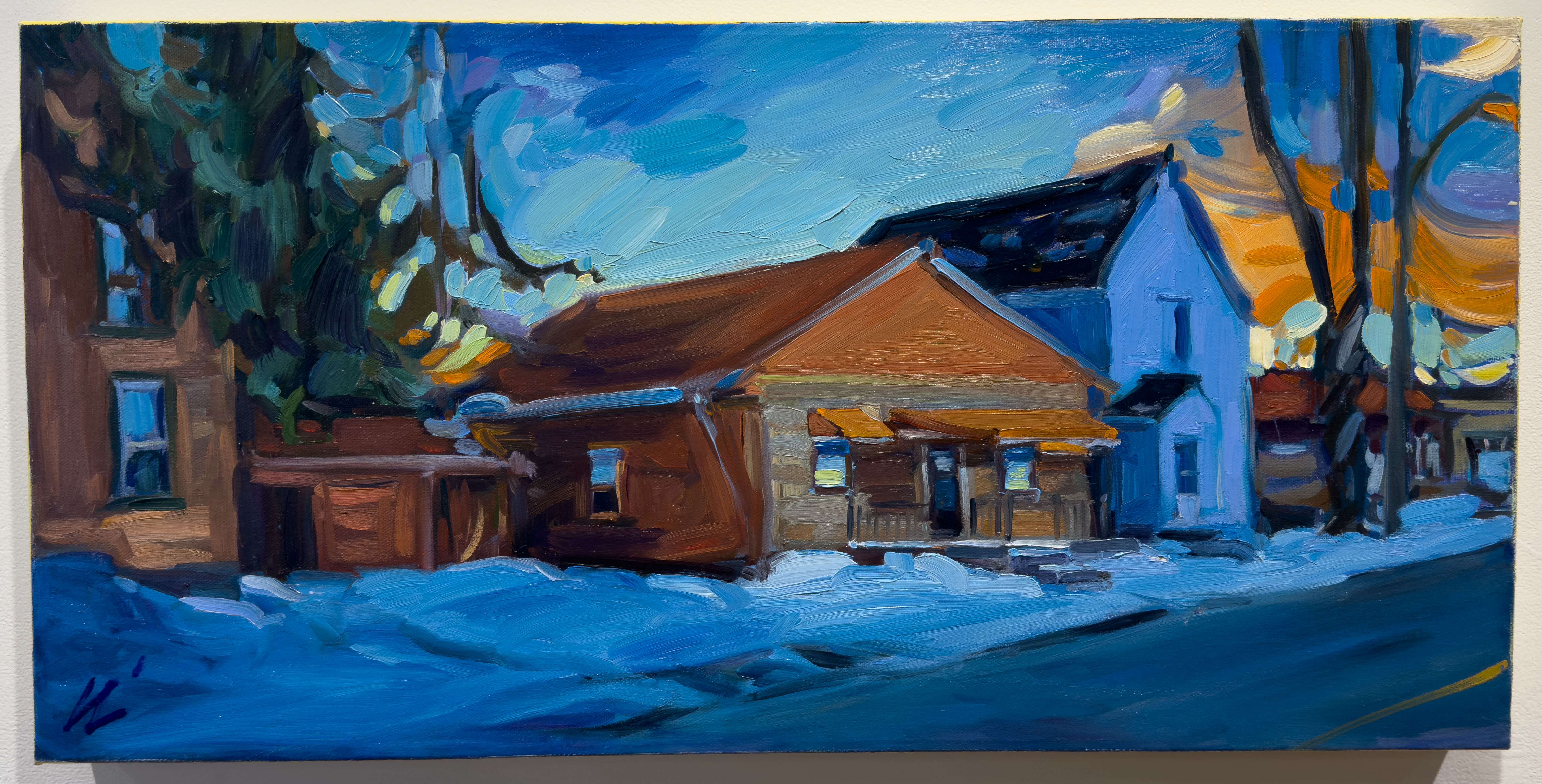 A orange building surrounded by a blue snowy day.