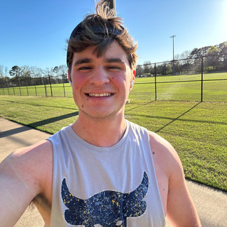 A guy smiling in a selfie of him on a run.