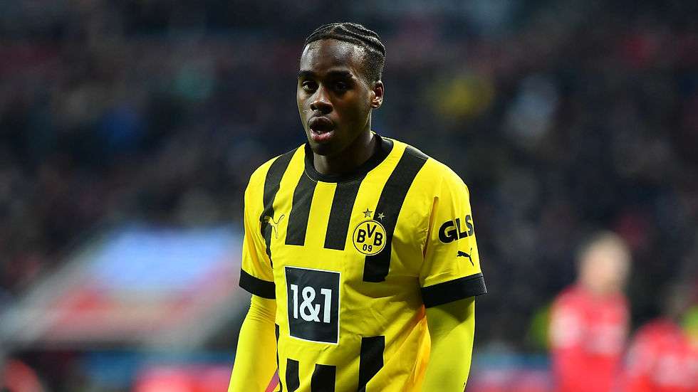 Soccer player in yellow and black striped jersey on field, showing determined expression. Logos: Puma, BVB 09, 1&1, GLS. Blurred crowd.