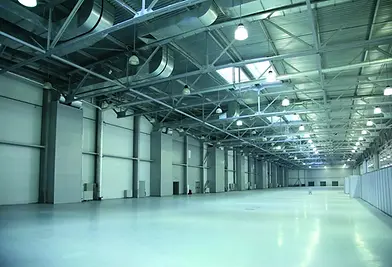 Große Lagerhalle mit weißem Boden und Metallkonstruktion, perspektivisch, leer.