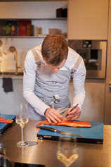 Sternekoch schneidet sorgfältig frischen Lachs für Gourmet-Kochkurs Aachen.