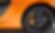 Nahaufnahme eines orangefarbenen Autos mit schwarzem Rad und gelber Bremse.
