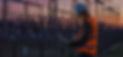 Ingenieur mit Laptop analysiert; Energieanlagen im Hintergrund; Abenddämmerung. E.GRUPPE