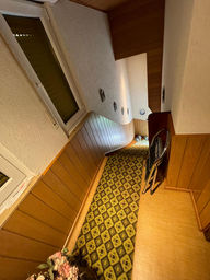 Treppe mit gemustertem Teppich und Holzgeländer