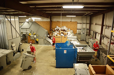 Staff sorting materials in a large recycling facility.