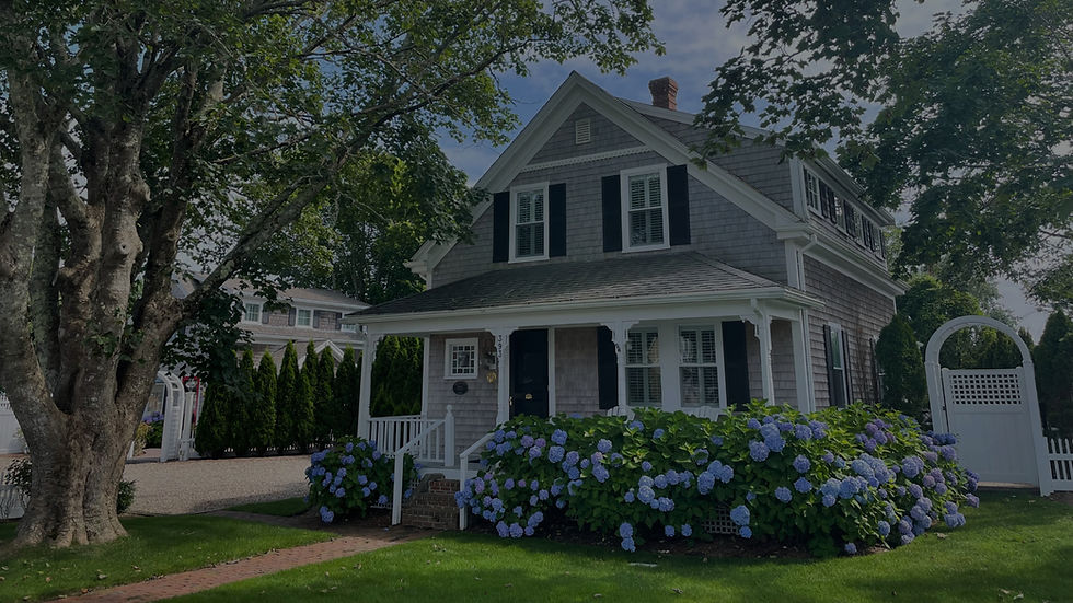 Grey house with front porch and blue hydrangeas