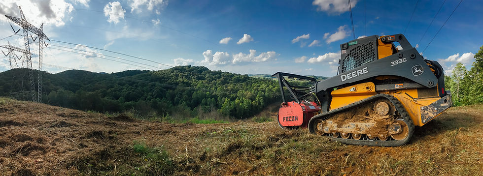 John Deere skid steer with mulcher clearing land on a hill
