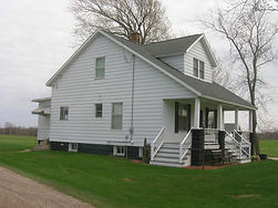 White two-story house with additions and renovations.