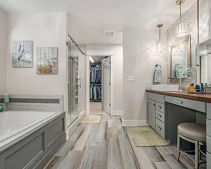 Remodeled bathroom with tub, vanity, and walk-in closet