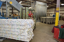 Worker operating a forklift to move secure shredded paper