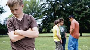 child socially excluded from three other children talking in a park