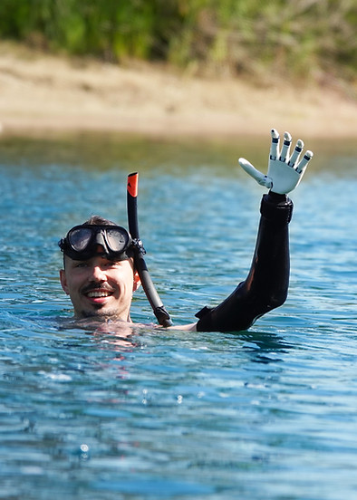 Wasserdichte Handprothese ragt teilweise aus der Wasseroberfläche eines Sees nach einem Tauchgang.