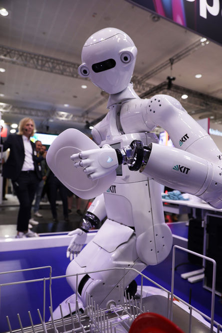 Humanoider Roboter hält weißen Teller mit präziser myoelektrischer Handprothese von Vincent Systems