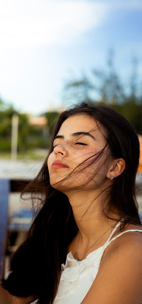 garota com olhos fechados e rosto em direção ao céu